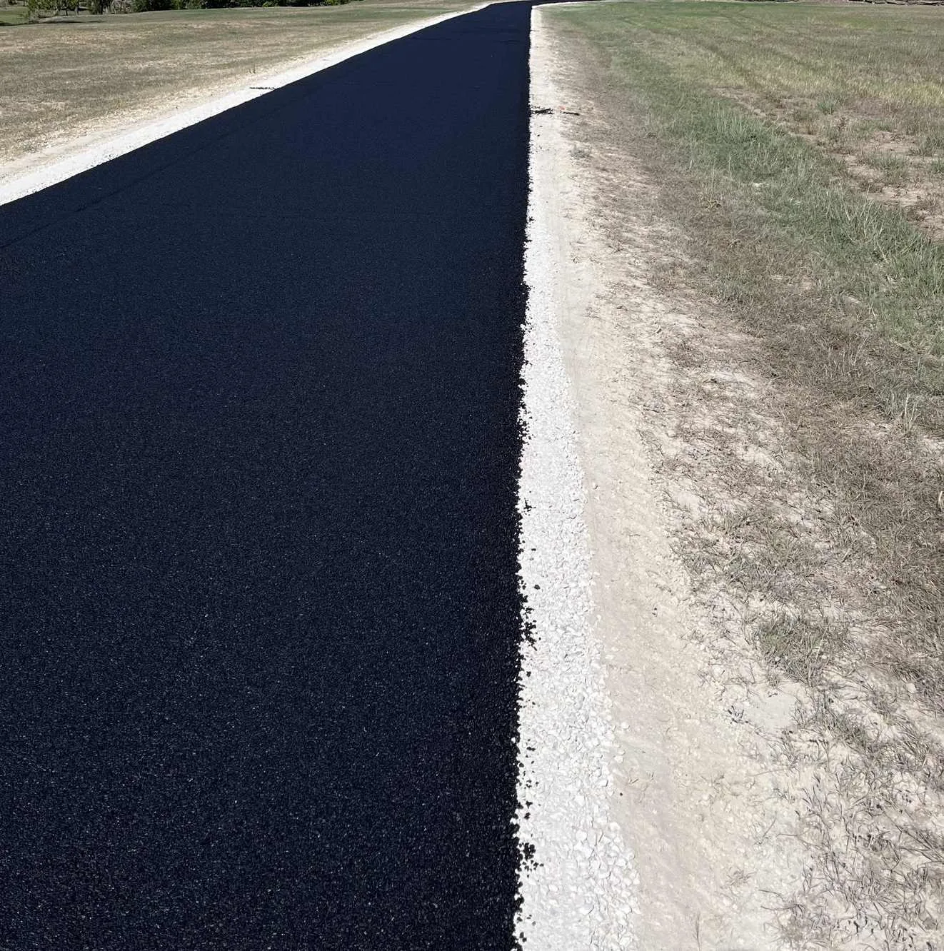 Clean asphalt edge beside gravel shoulder