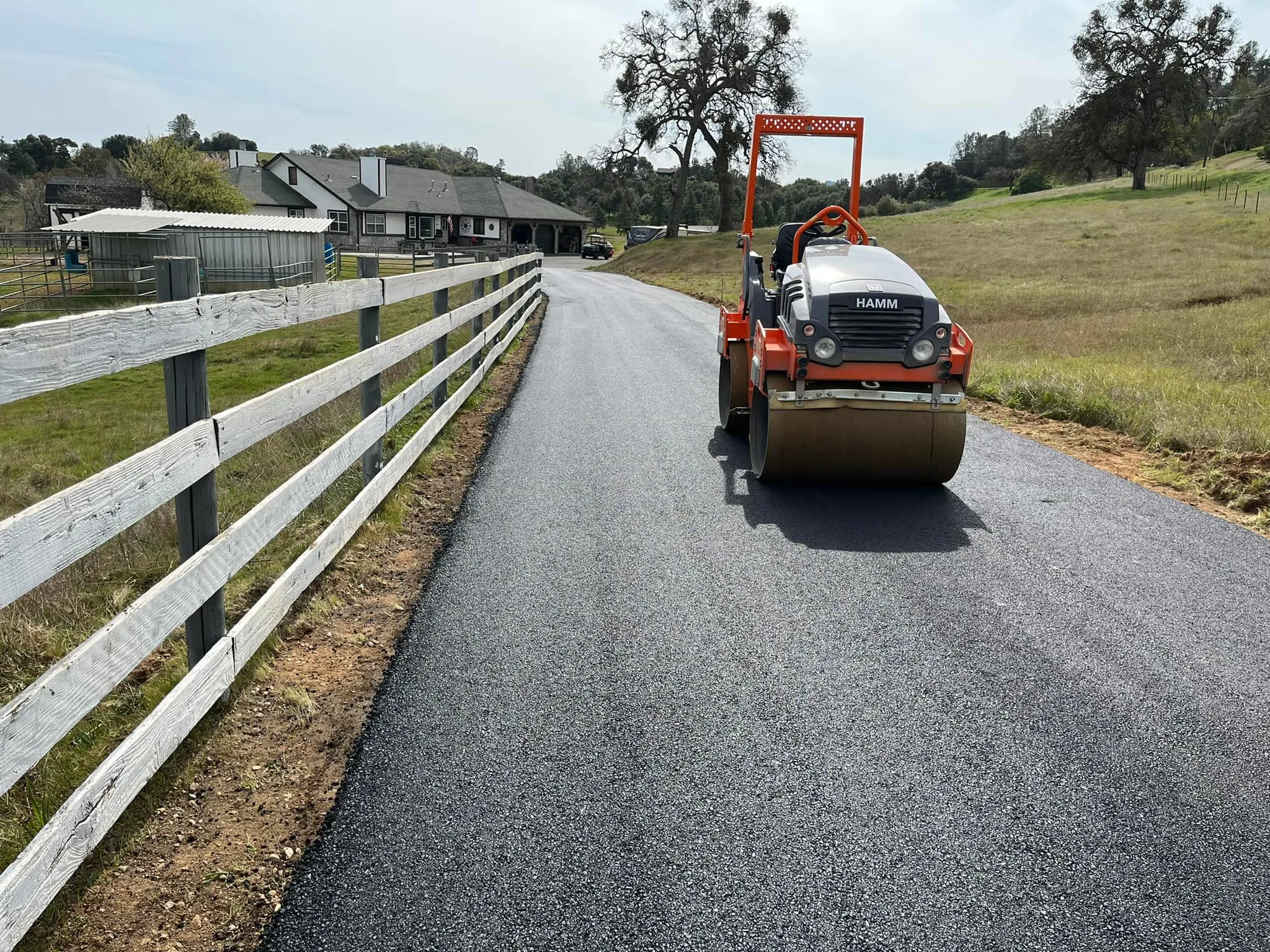 Roller compacting a long paved rural driveway